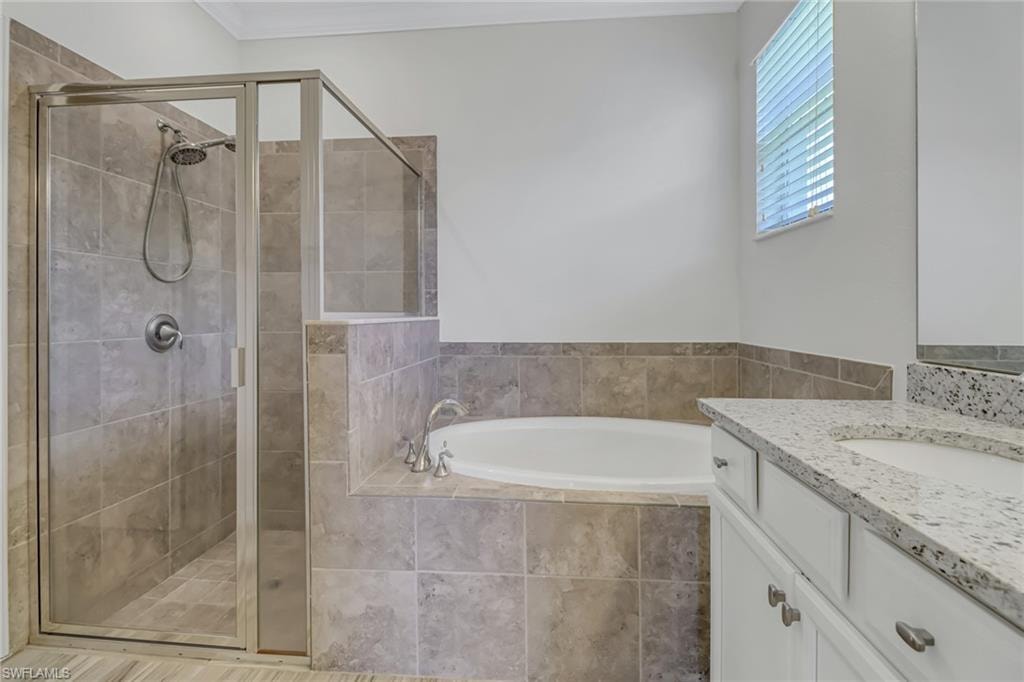 Primary Bathroom featuring a garden tub, vanity, and a stall shower