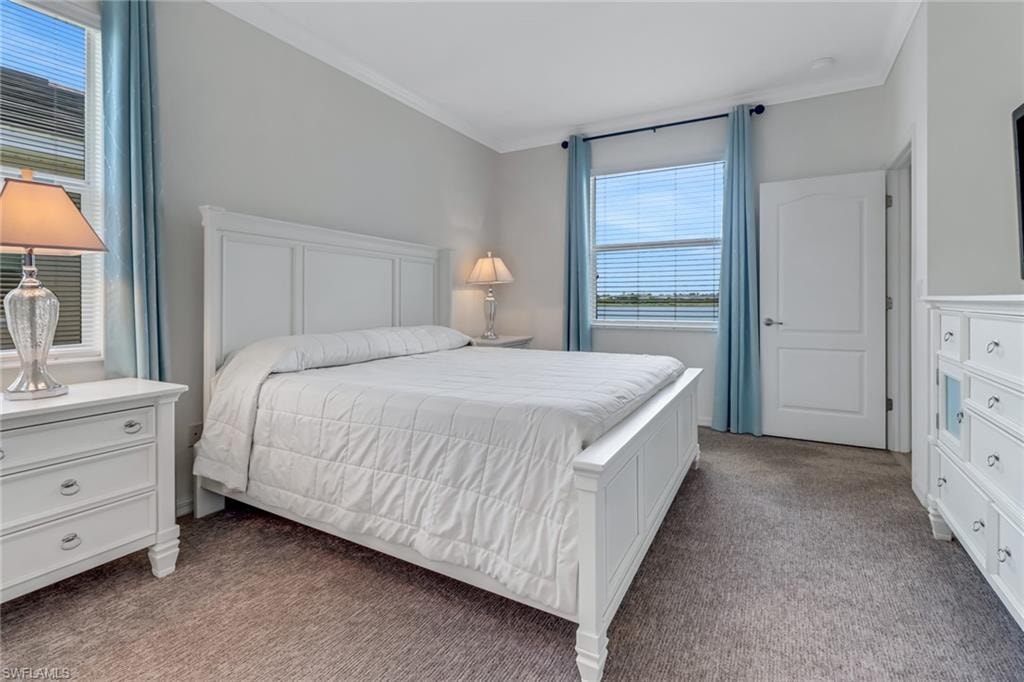 Primary Bedroom with carpet and ornamental molding