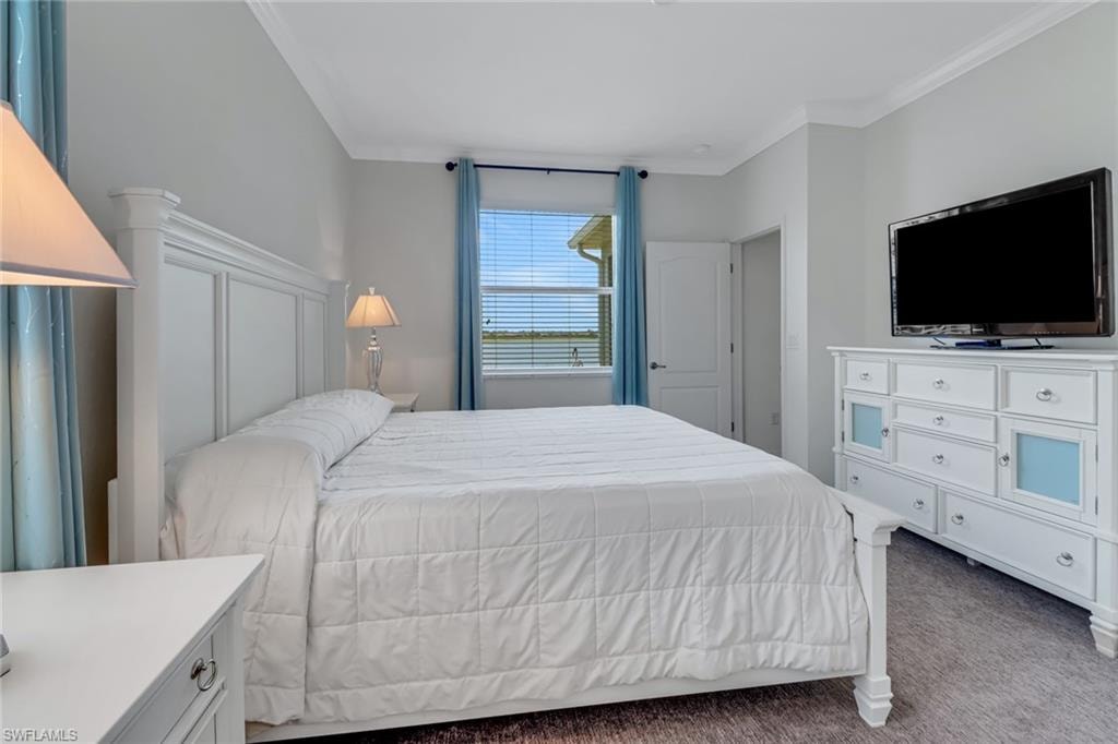 Primary Bedroom featuring ornamental molding and carpet