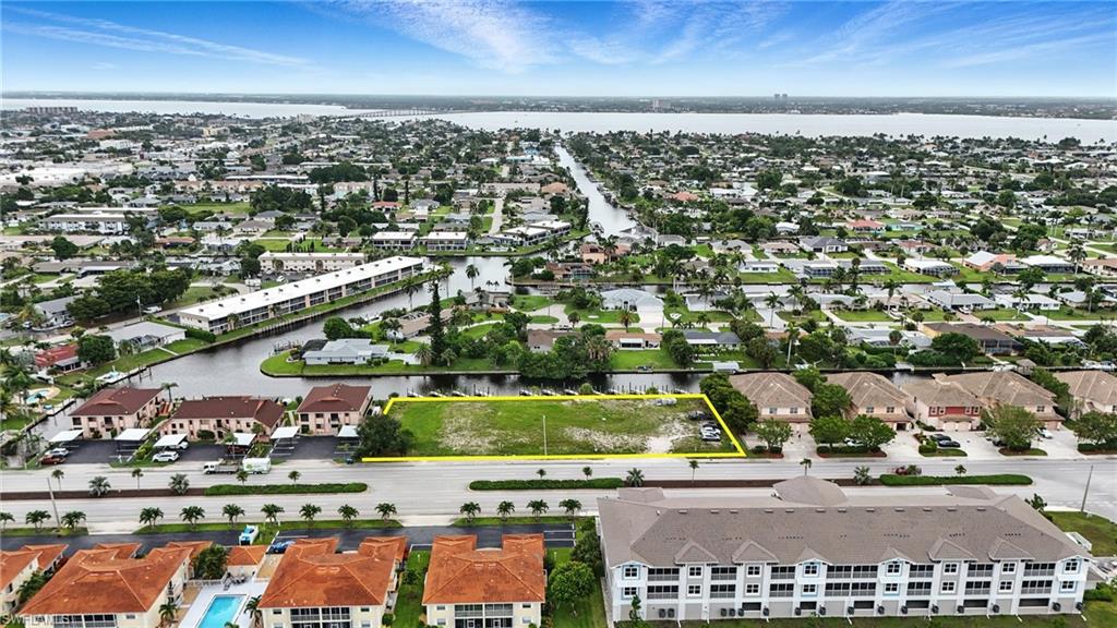 Aerial perspective of suburban area featuring property parcel outlined and a large body of water