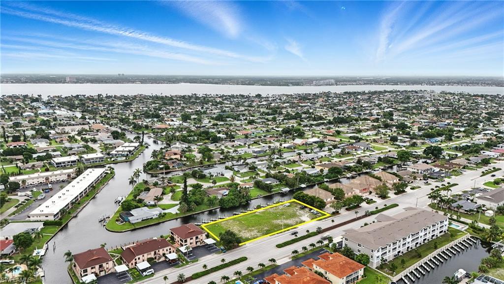 Aerial view of residential area featuring property parcel outlined and a large body of water