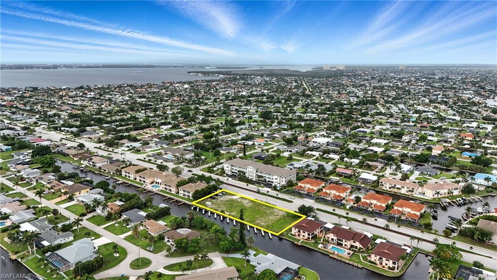 Aerial view of residential area with property parcel outlined and a large body of water