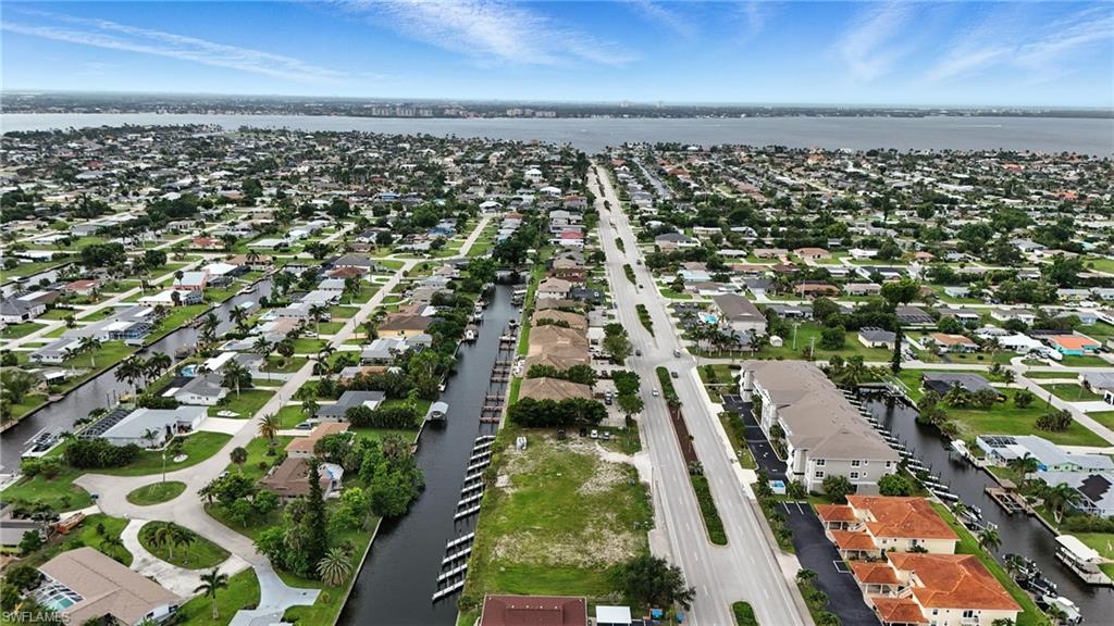 Aerial overview of property's location featuring a nearby body of water and nearby suburban area