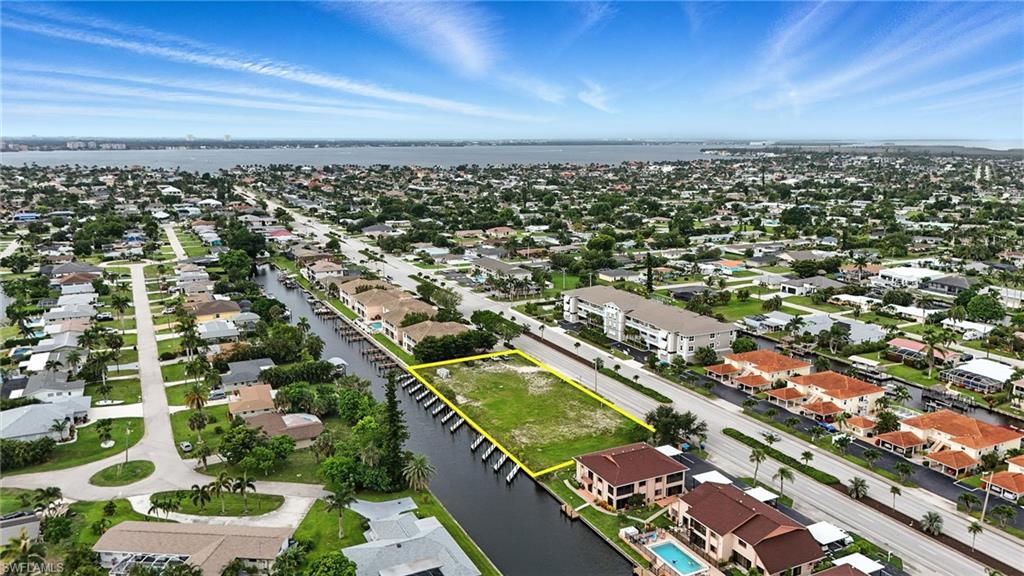 Aerial perspective of suburban area with a nearby body of water and property parcel outlined