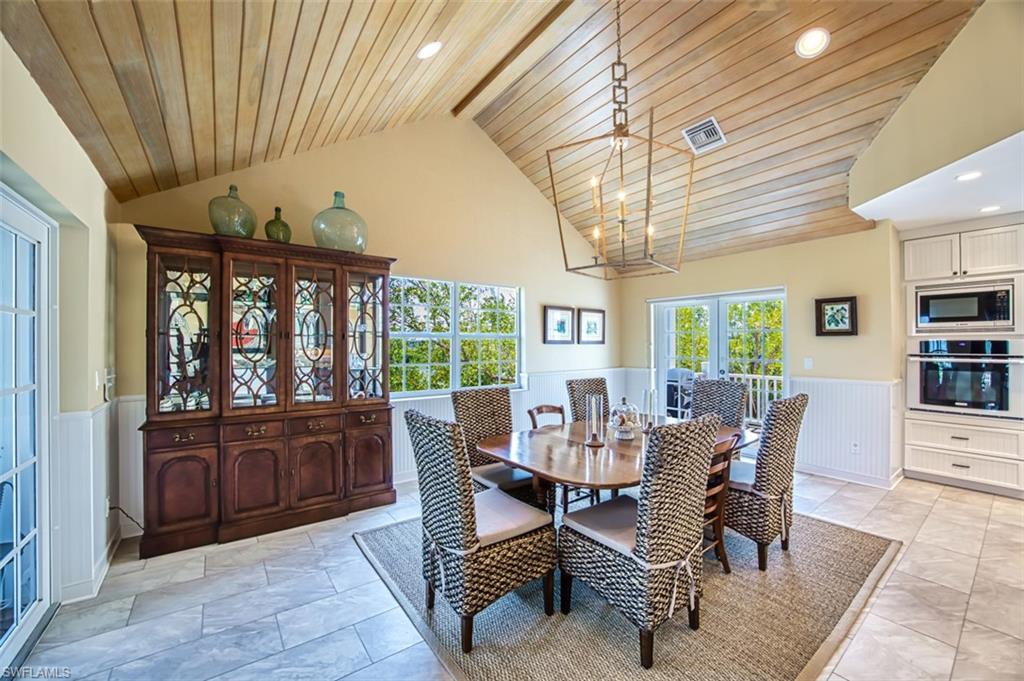 Dining Room Featuring Wainscoted Wall, Wooden Ceiling, Recessed Lighting, French Doors, And High Vaulted Ceiling