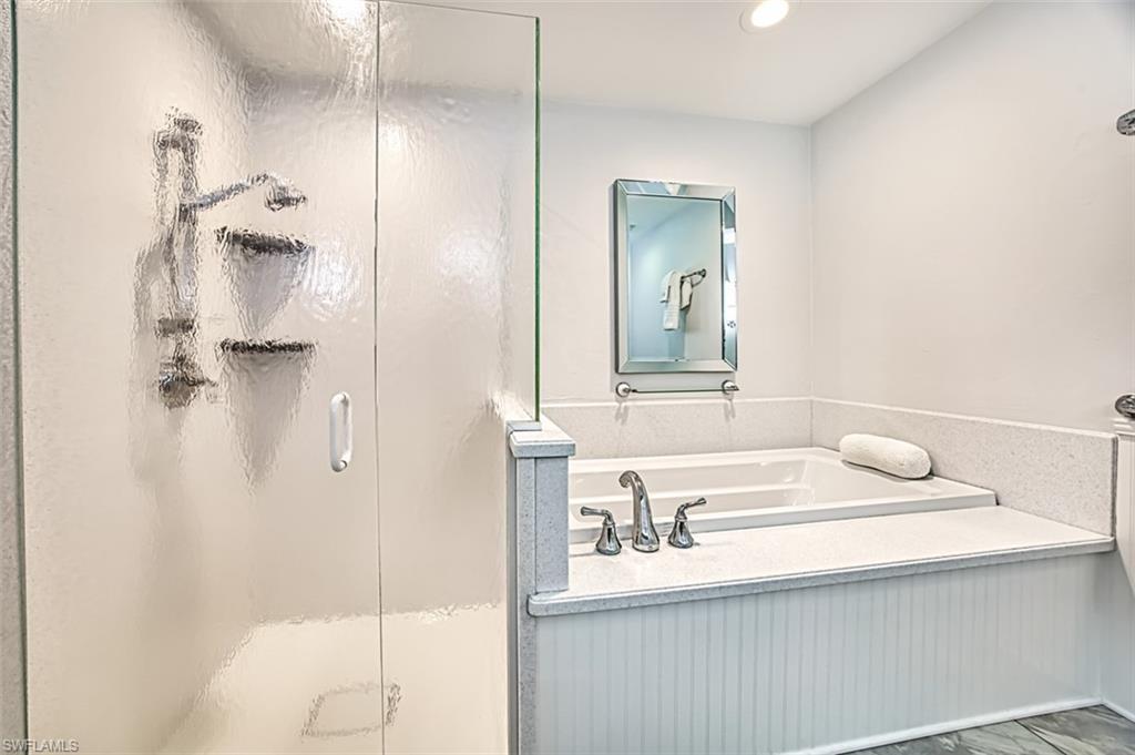 Bathroom with a stall shower, a garden tub, and recessed lighting