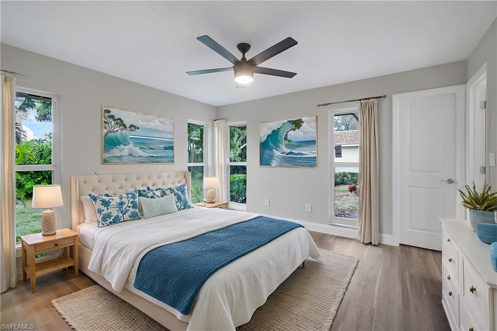 Bedroom featuring ceiling fan, light hardwood / wood-style flooring, and multiple windows