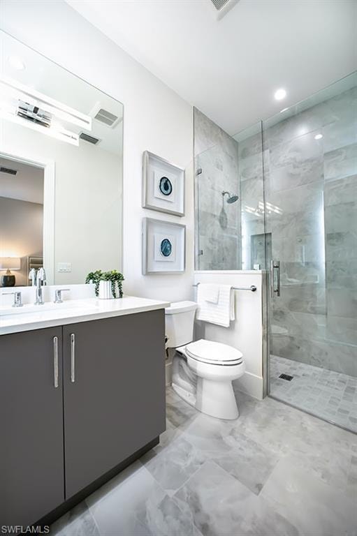Bathroom with vanity, a shower stall, light marble finish floors, and recessed lighting
