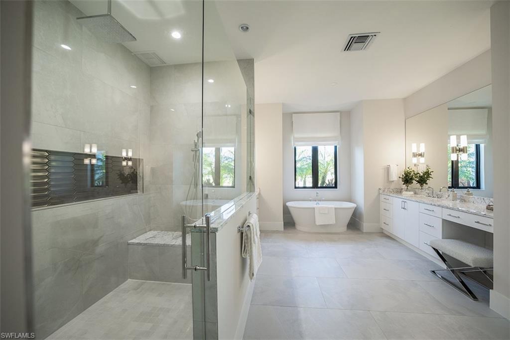 Bathroom with vanity, a shower stall, a soaking tub, recessed lighting, and light tile patterned floors
