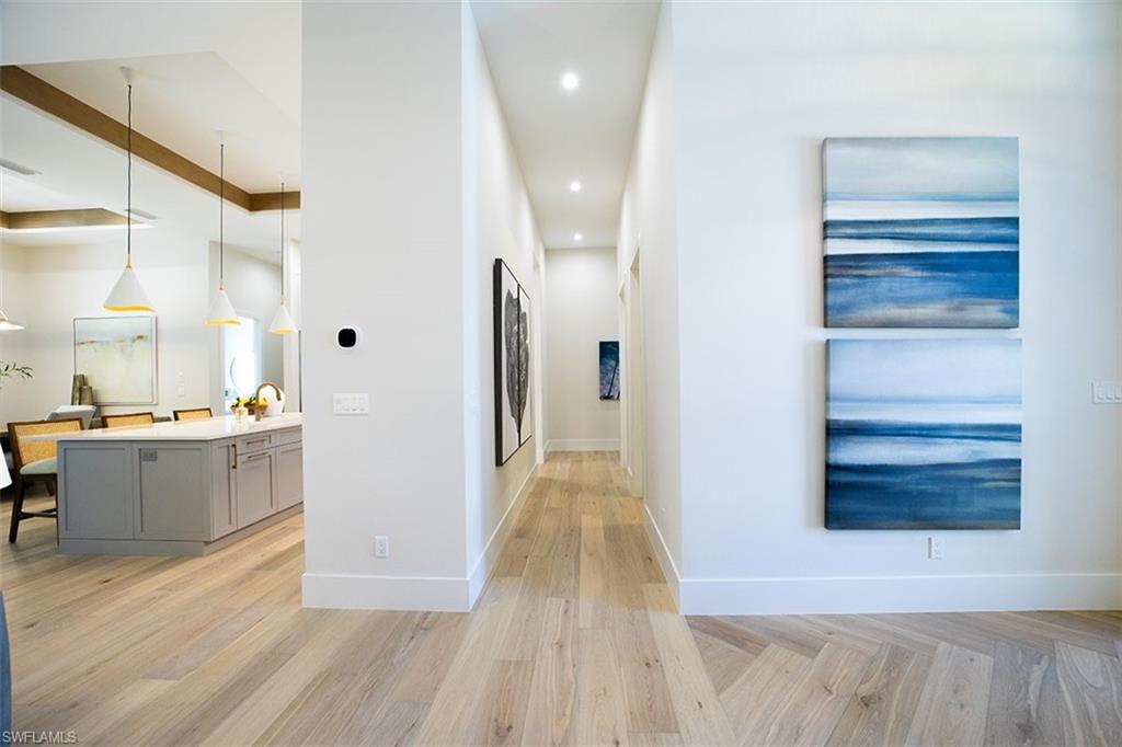 Corridor with parquet flooring and recessed lighting