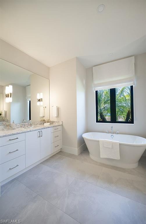 Full bathroom featuring vanity and a freestanding tub