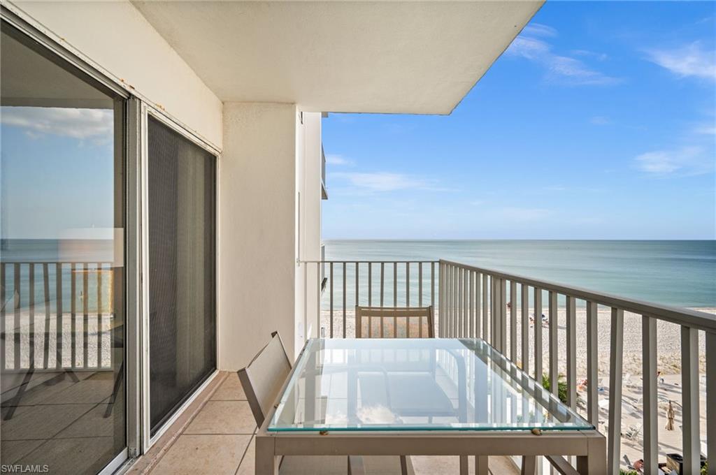 Balcony featuring view of water and beach
