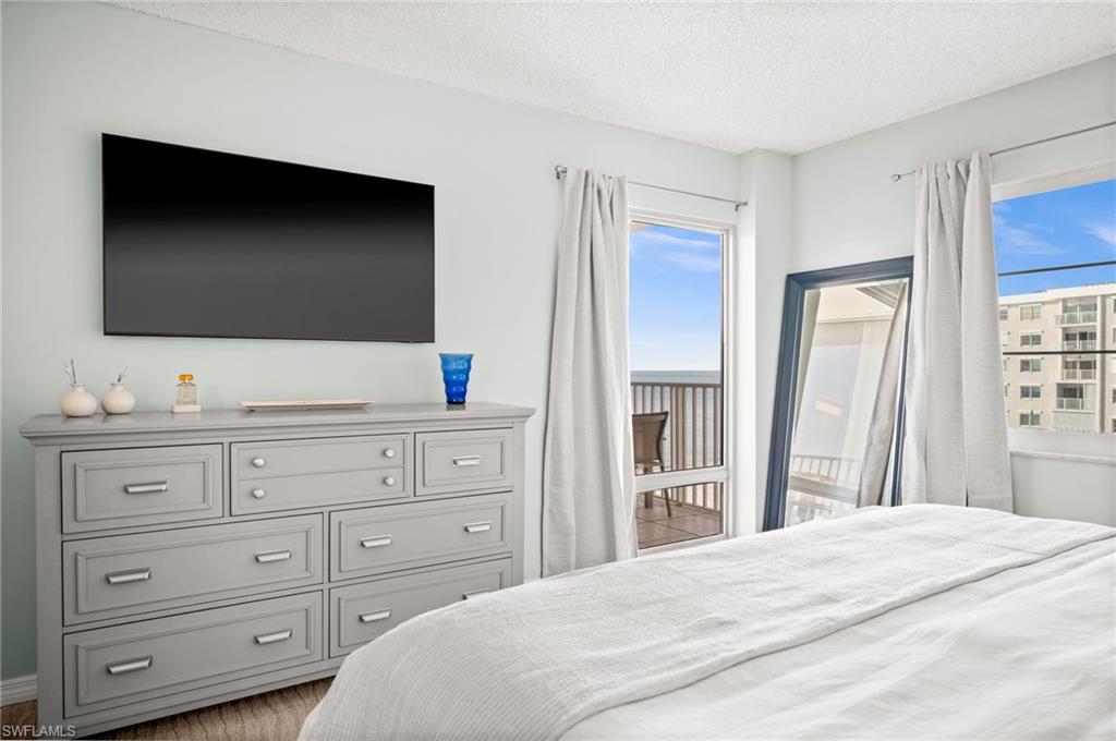 Bedroom with access to outside, a textured ceiling, and light wood-style floors