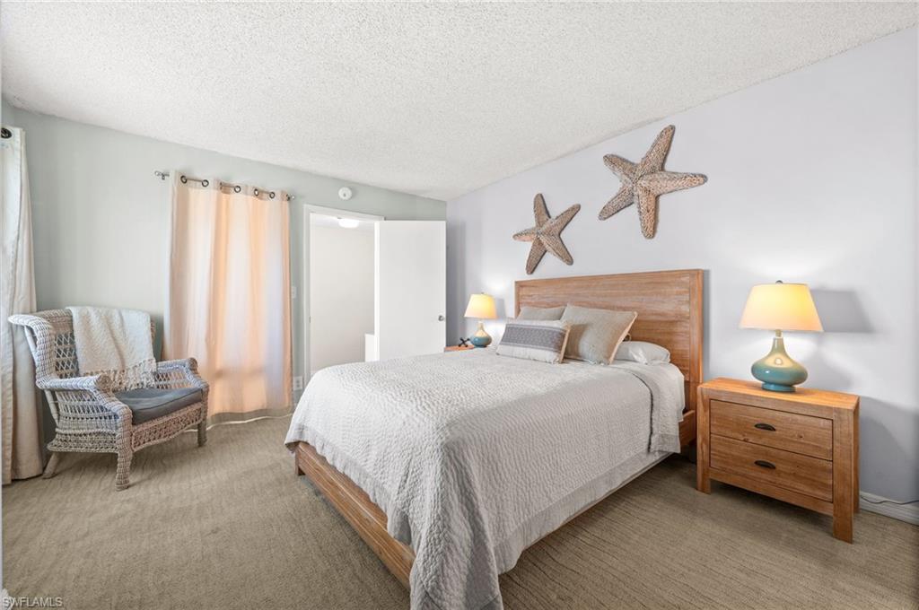 Bedroom with a textured ceiling and carpet flooring