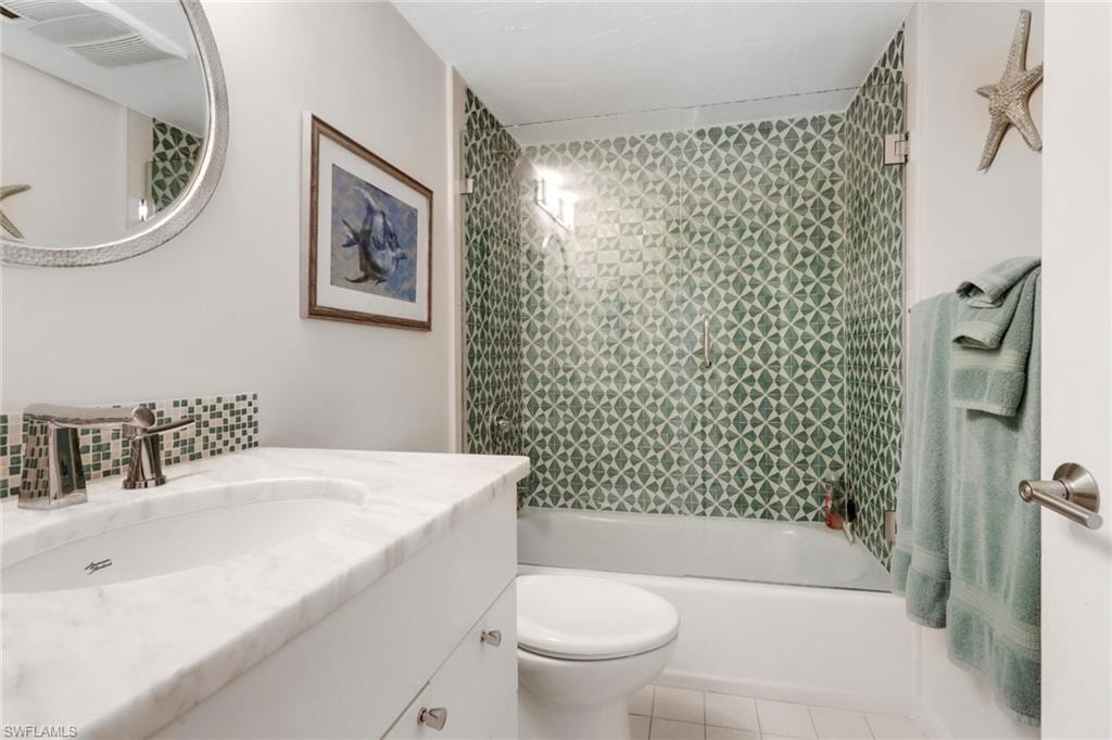 Bathroom with vanity,  shower combination, tile patterned floors, and tasteful backsplash