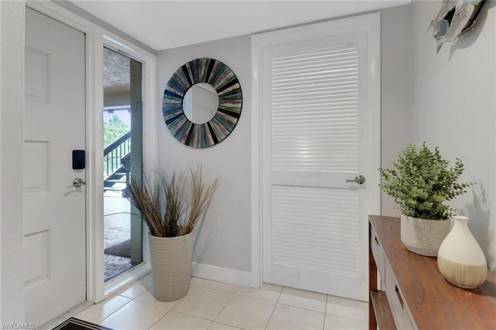 Foyer with baseboards and light tile patterned floors