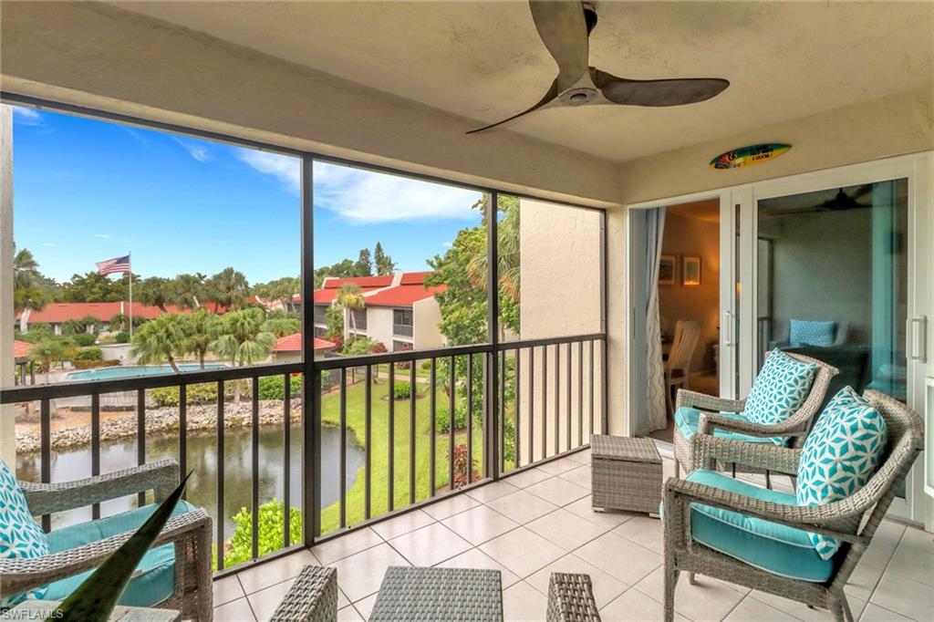 Sunroom / solarium with a ceiling fan and a water view