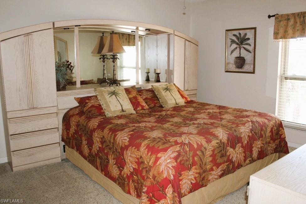 Carpeted bedroom with arched walkways