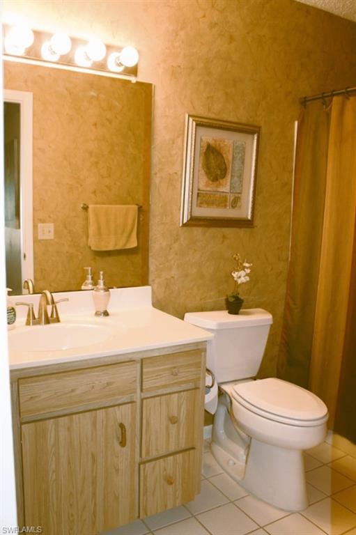 Bathroom with tile patterned flooring, vanity, and a shower with shower curtain