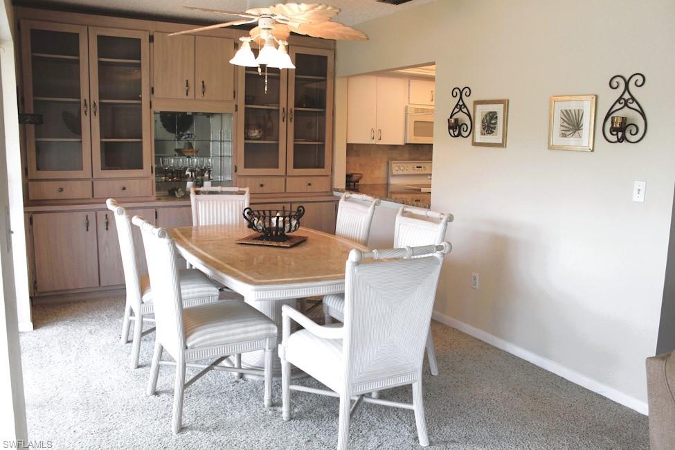 Dining room featuring ceiling fan and light carpet