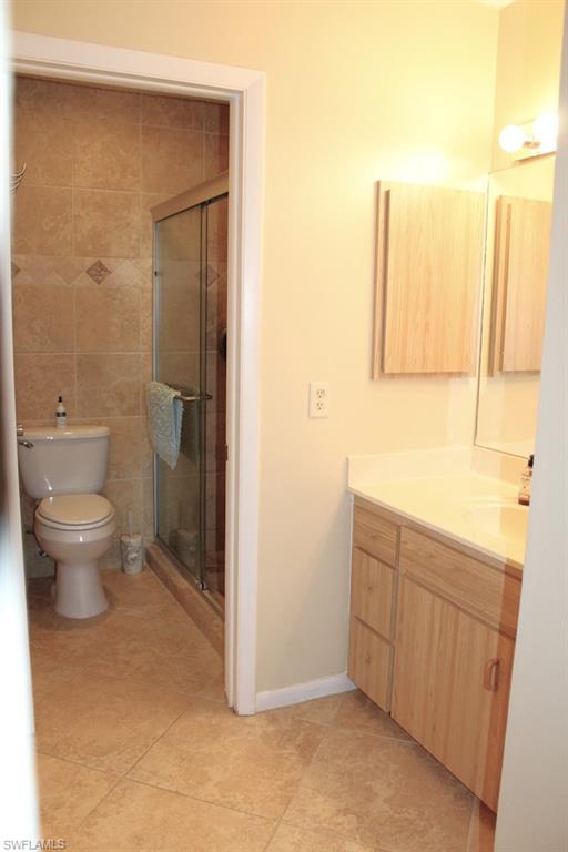 Full bath featuring vanity, tile patterned flooring, and a stall shower
