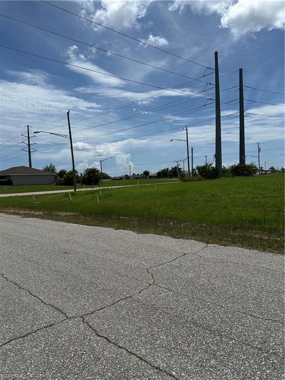 View of asphalt road featuring street lights