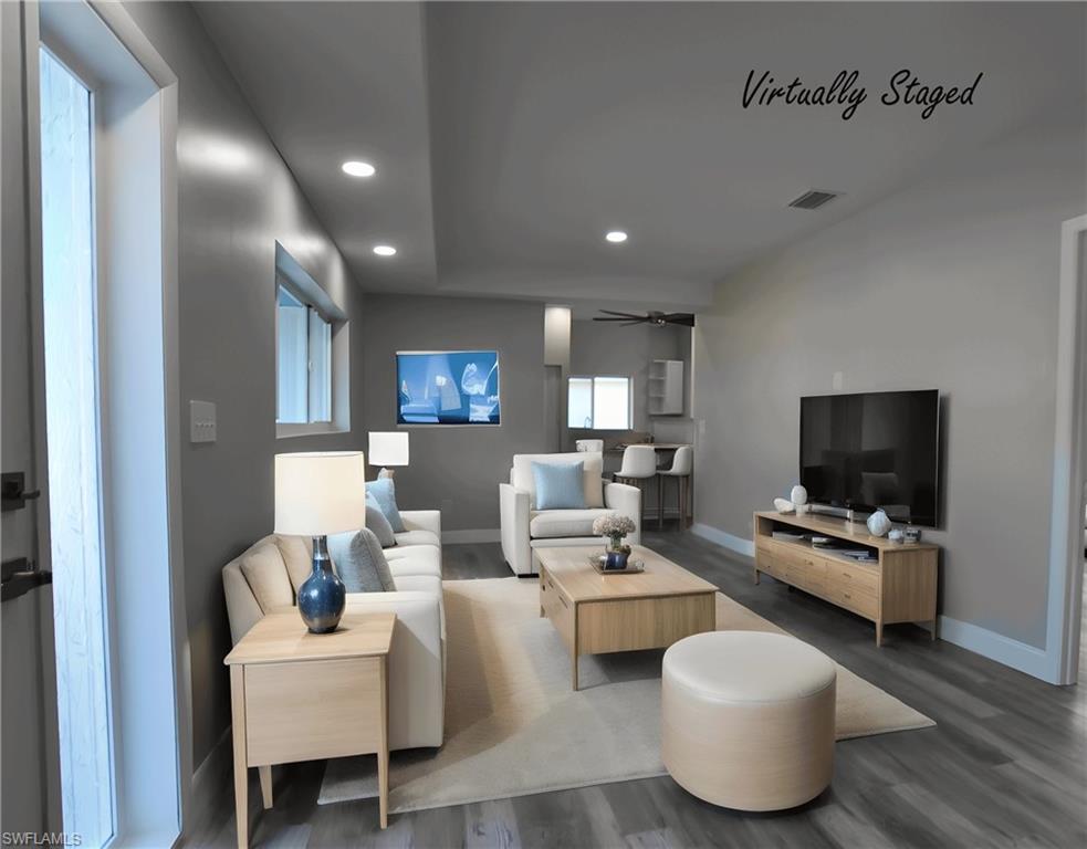Living room with LVP floors, a ceiling fan, and recessed lighting