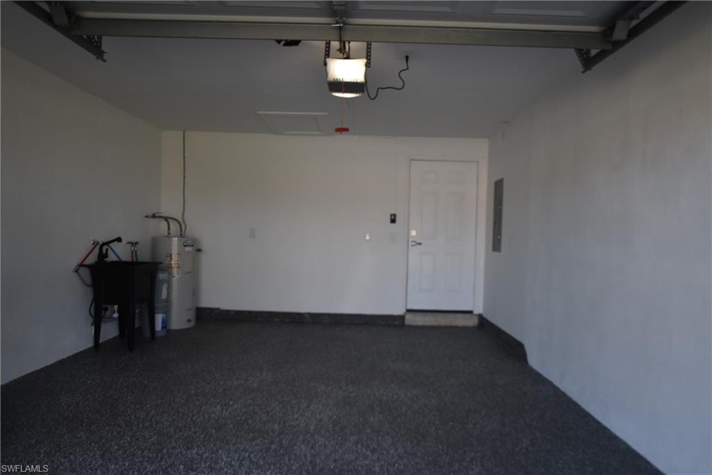 Garage with secured water heater, a garage door opener, and electric panel