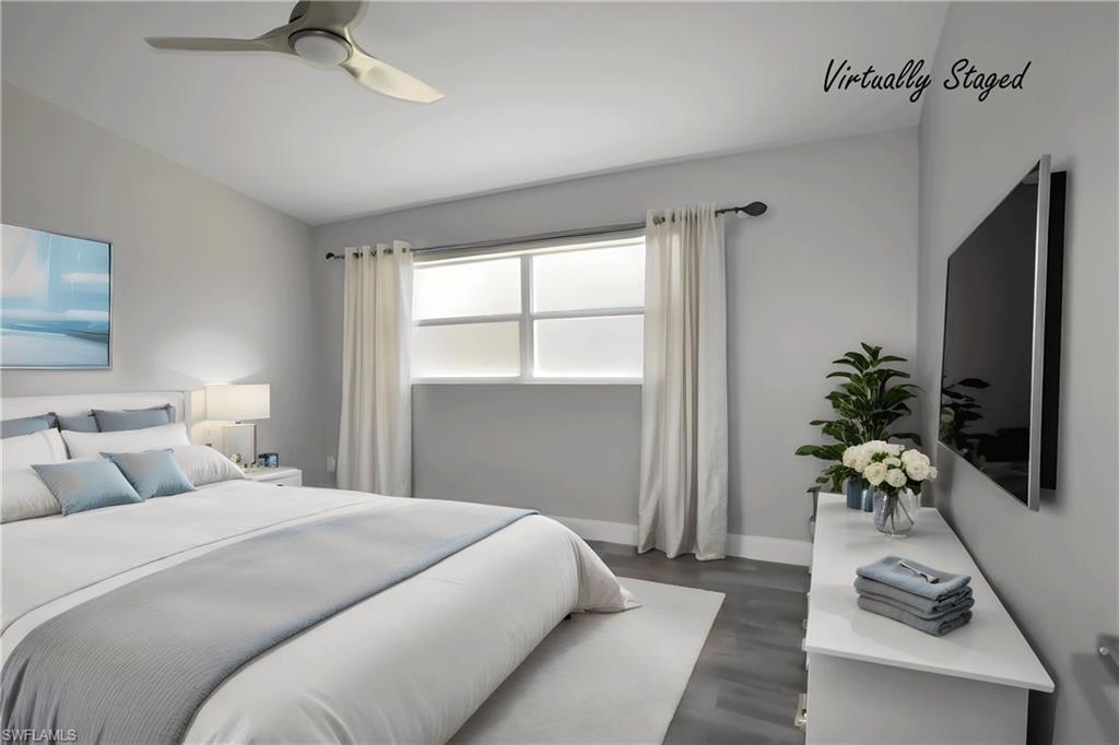 Bedroom with lofted ceiling, LVP floors, and a ceiling fan
