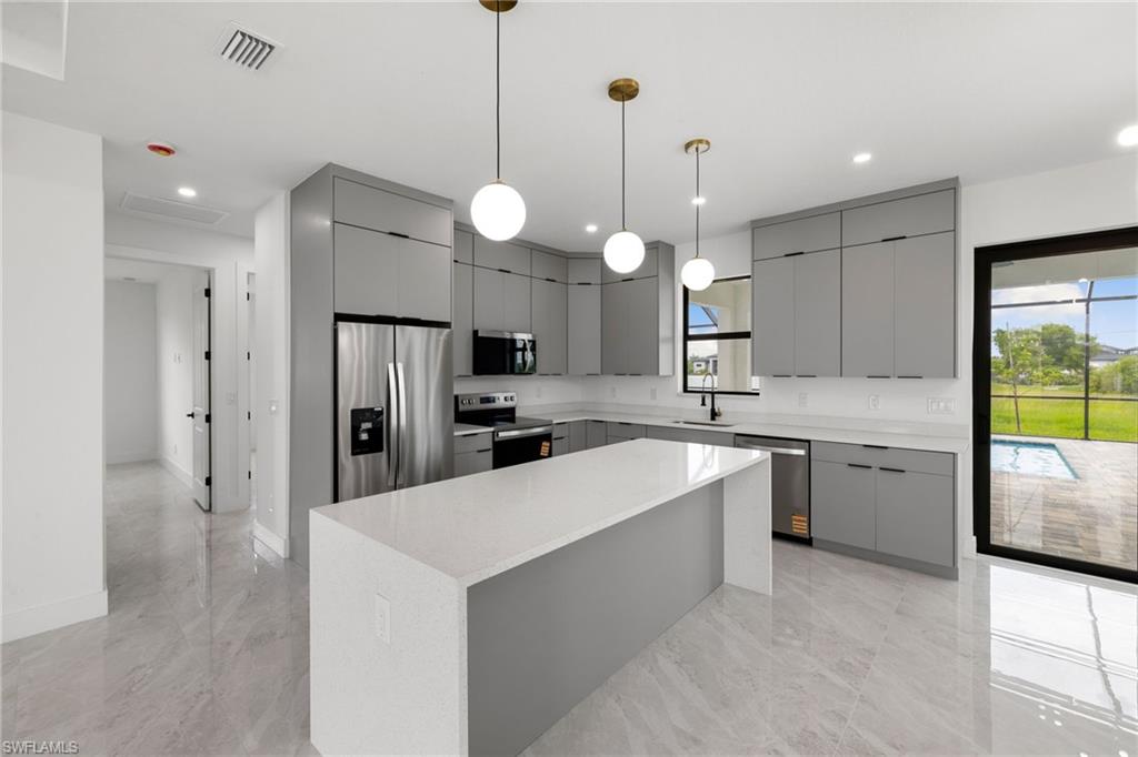 Kitchen featuring appliances with stainless steel finishes, gray cabinetry, modern cabinets, plenty of natural light, and recessed lighting