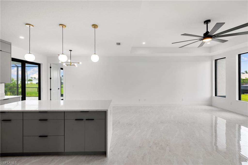 Kitchen featuring gray cabinets, modern cabinets, plenty of natural light, light countertops, and recessed lighting