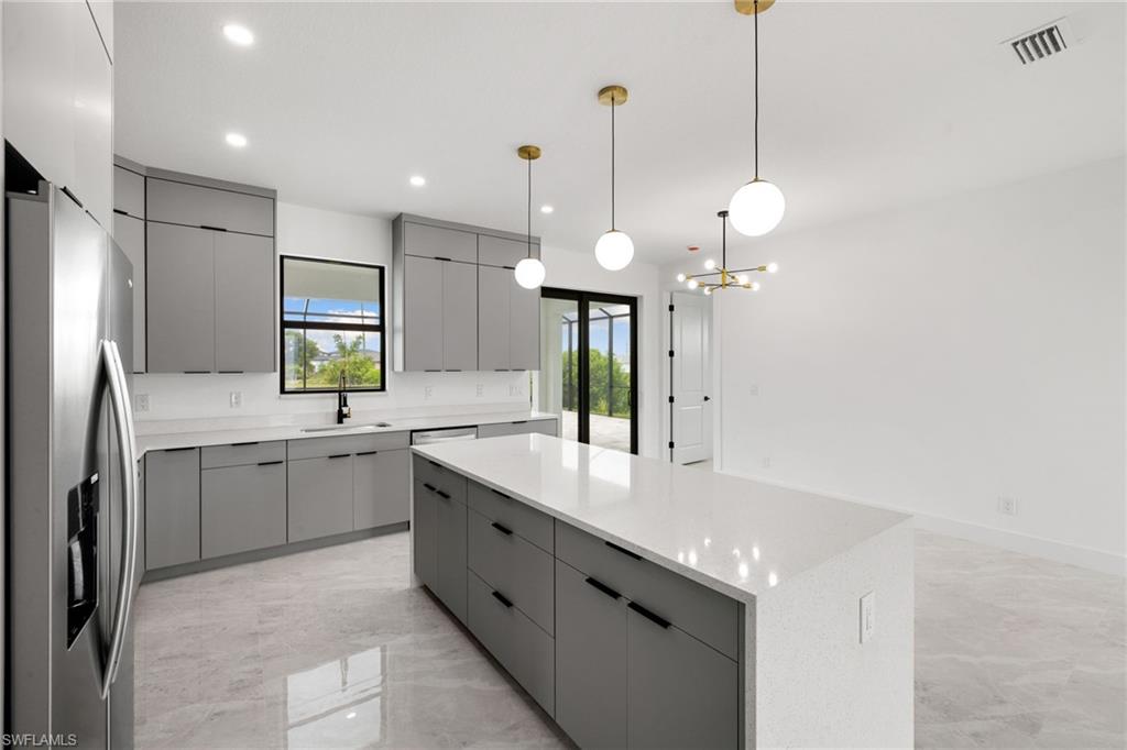 Kitchen with gray cabinets, stainless steel refrigerator with ice dispenser, modern cabinets, a kitchen island, and light marble finish floors