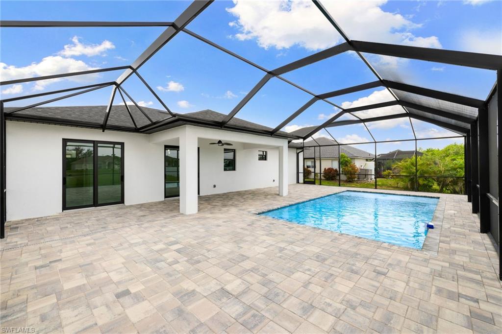 Swimming pool with a patio, a ceiling fan, and glass enclosure