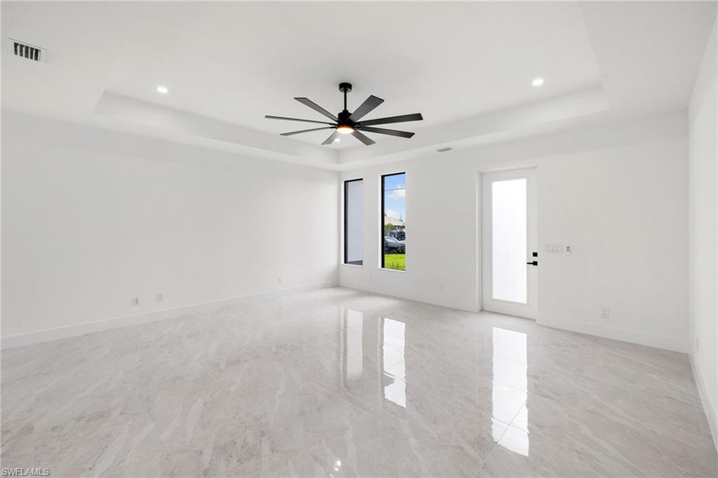 Unfurnished room with a tray ceiling, recessed lighting, and ceiling fan