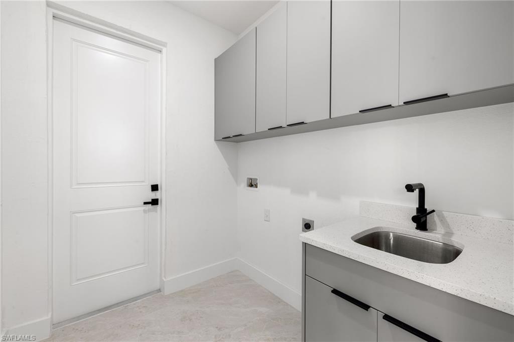 Laundry room with electric dryer hookup, hookup for a washing machine, and cabinet space