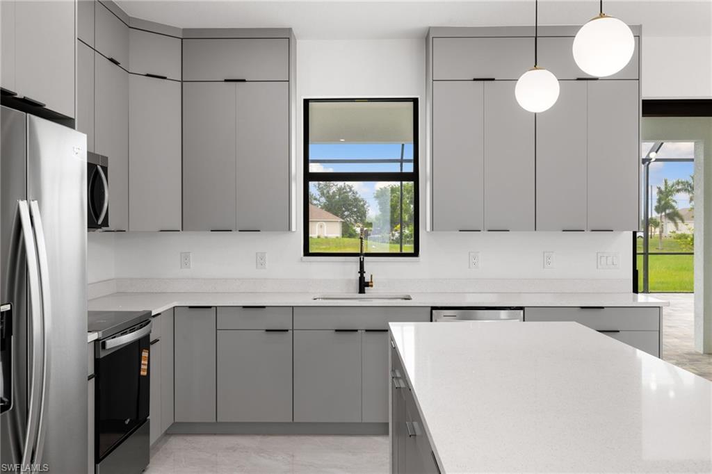 Kitchen with stainless steel appliances, gray cabinetry, modern cabinets, and light countertops