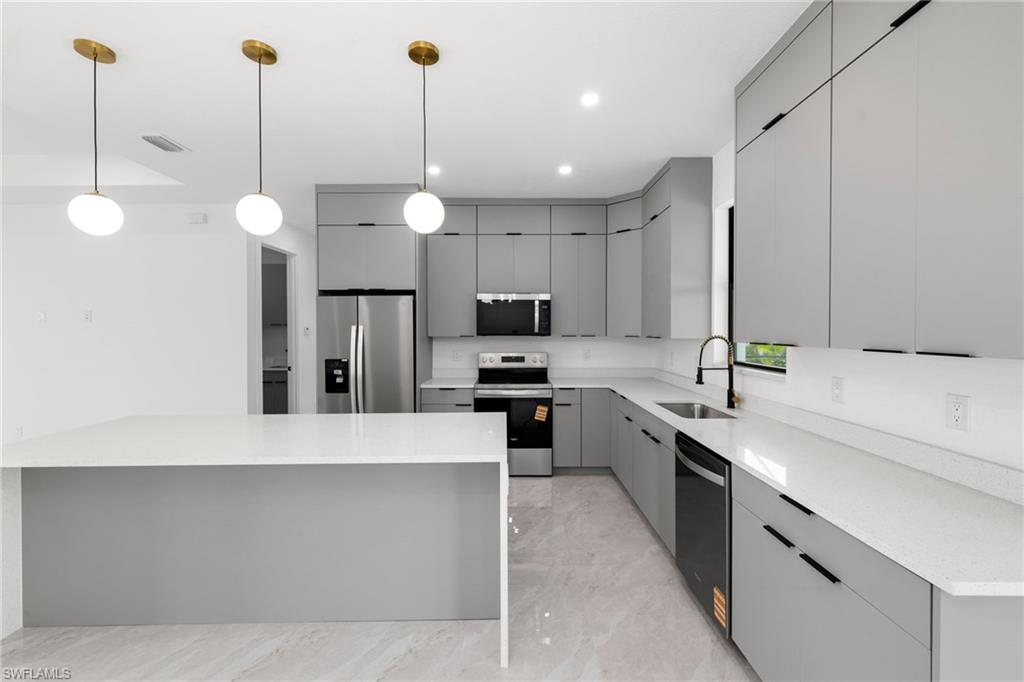 Kitchen featuring stainless steel appliances, gray cabinetry, light marble finish floors, modern cabinets, and light countertops