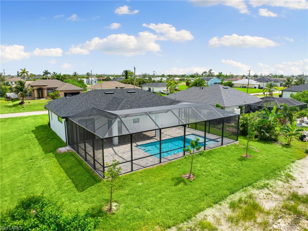 Outdoor pool featuring a residential view, a patio area, a lawn, and a lanai