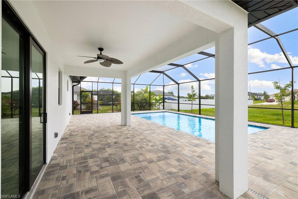 Swimming pool featuring ceiling fan, a lanai, and a patio