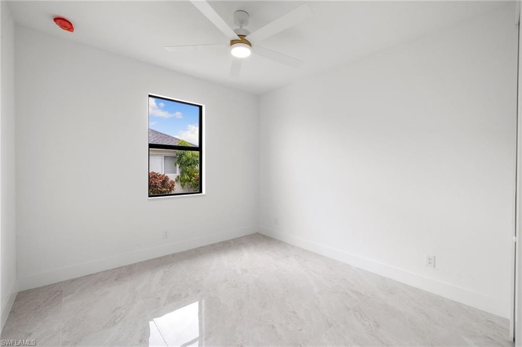 Spare room featuring ceiling fan and baseboards