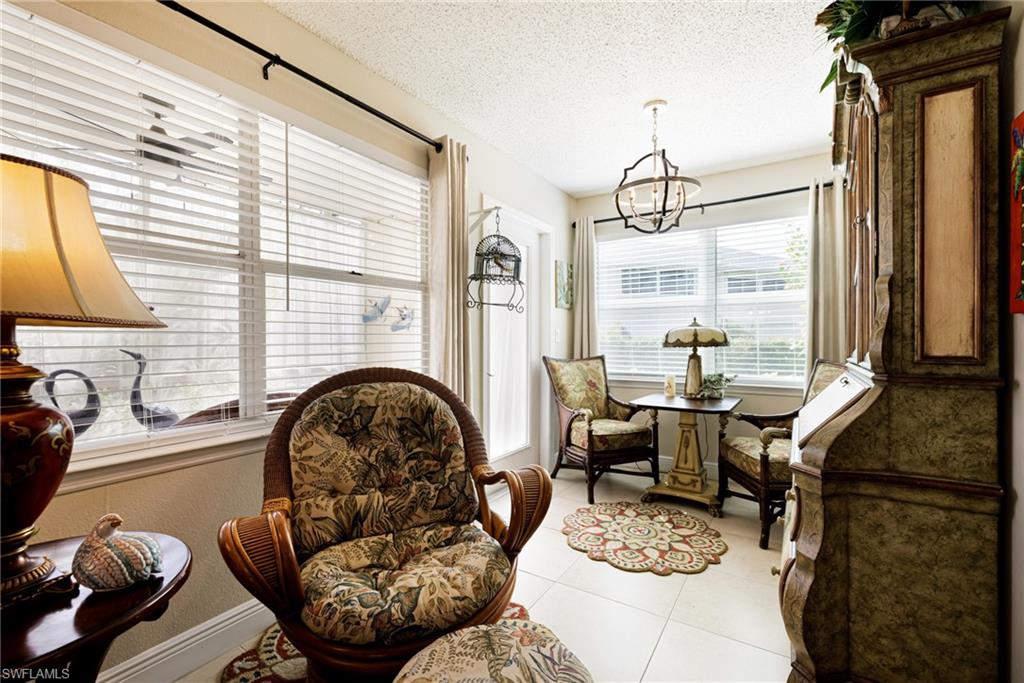 Sitting room with a chandelier, light tile patterned floors, and a textured ceiling