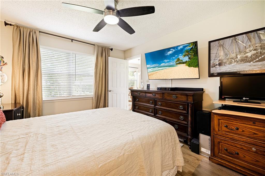 Bedroom featuring a textured ceiling, wood finished floors, and a ceiling fan
