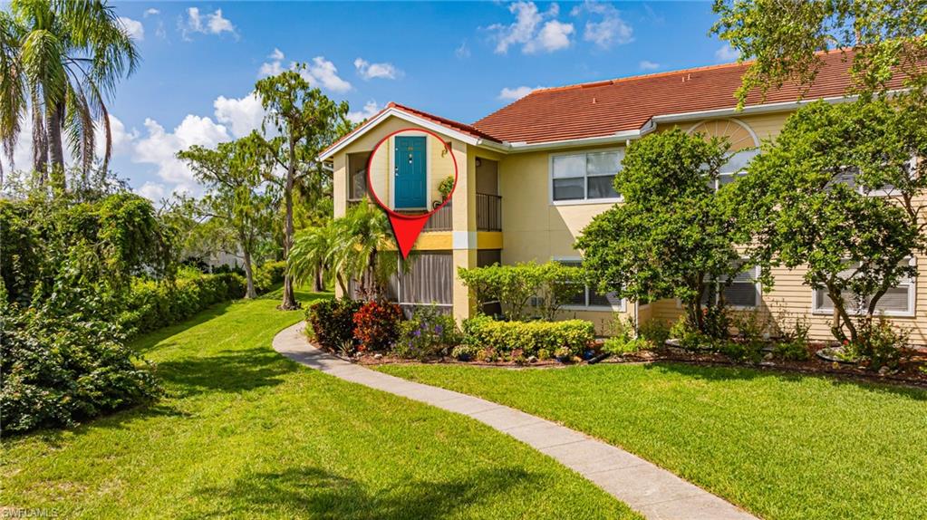 View of front of property featuring a front yard, stucco siding, and a tile roof