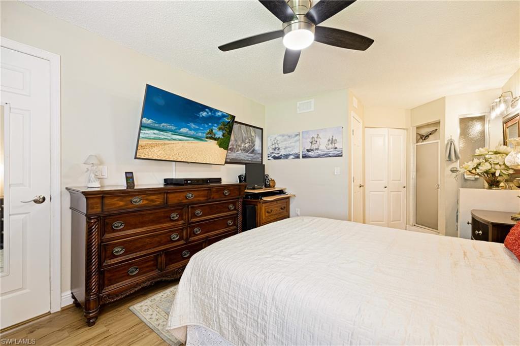 Bedroom with light wood-style flooring, ceiling fan, and a closet