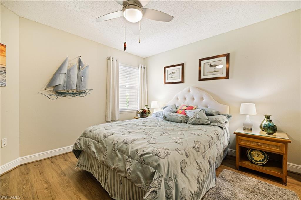 Bedroom featuring wood finished floors, a textured ceiling, and a ceiling fan