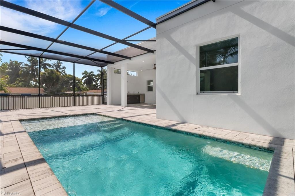 Swimming pool featuring a patio area and glass enclosure