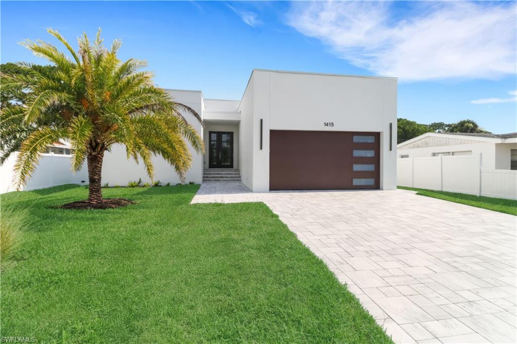 Modern home with decorative driveway, stucco siding, and a garage