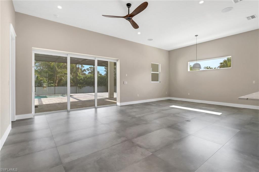 Unfurnished room featuring healthy amount of natural light, a ceiling fan, and recessed lighting