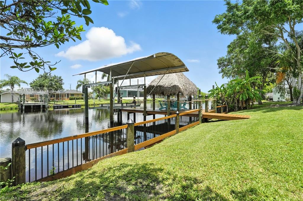 Dock with a water view,  Boat Lift w/Canopy Cover & Tiki Hut