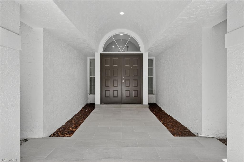 Entrance to property featuring stucco siding and tile entry